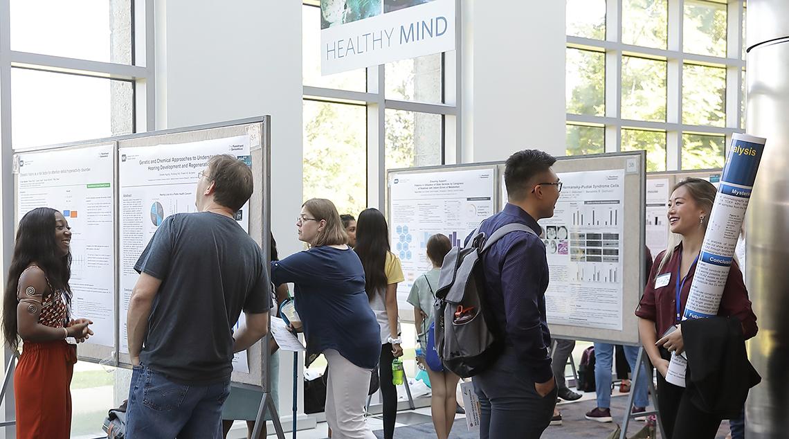 Youngsters mill around at crowded poster session.