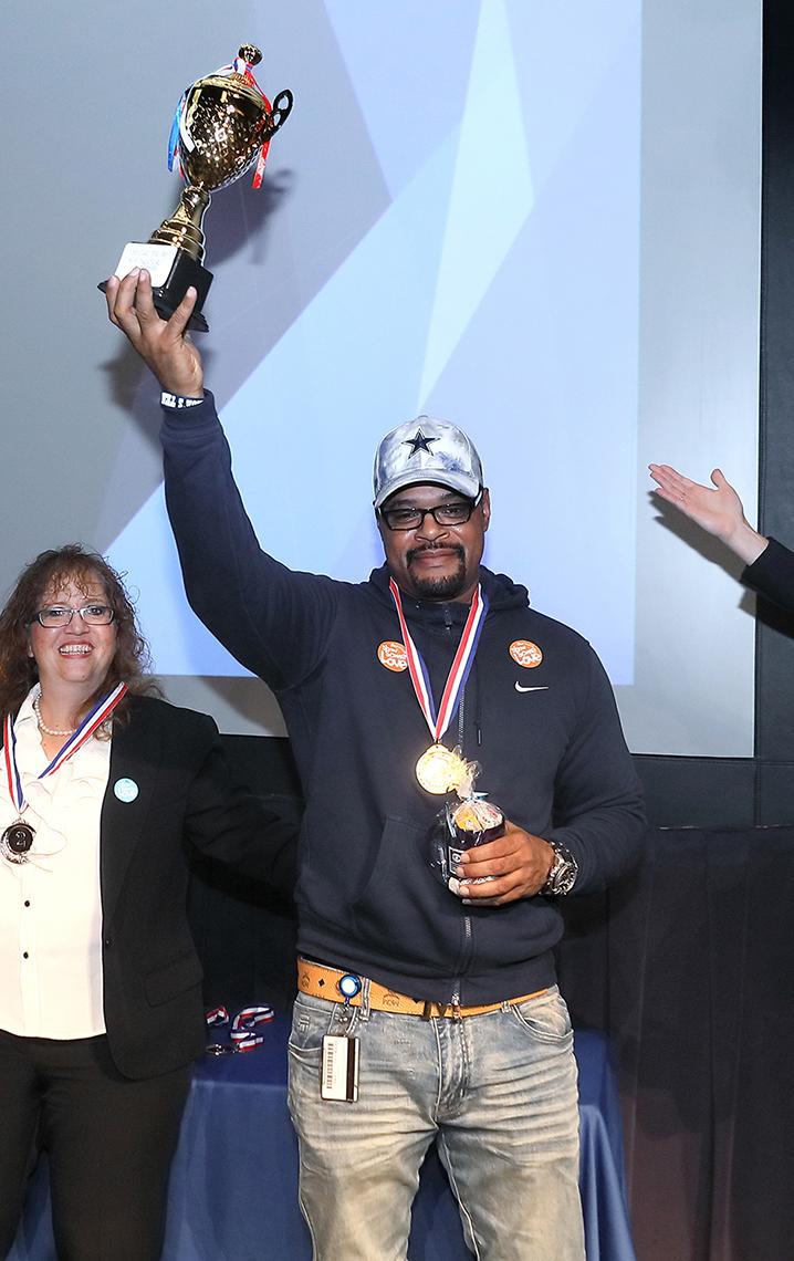 Steele raises trophy above his head.