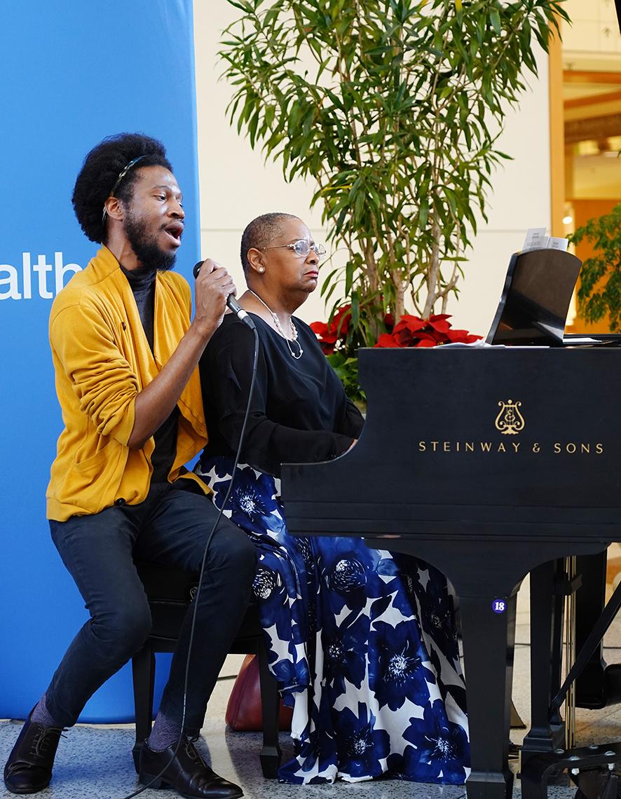 Aaron Reeder sings, with a pianist behind him, accompanying.