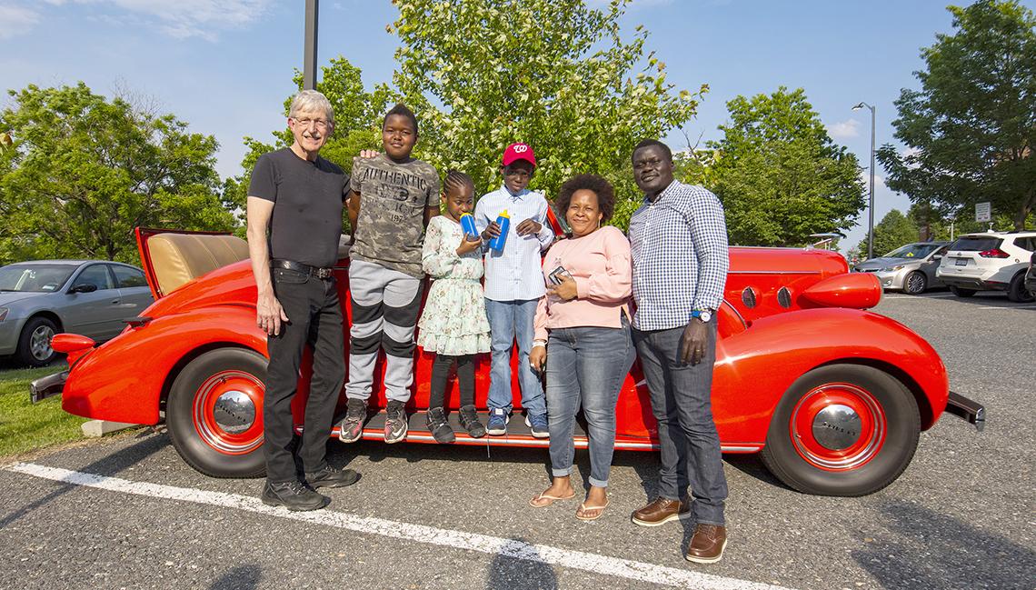 Collins and Inn family smile in front of show car