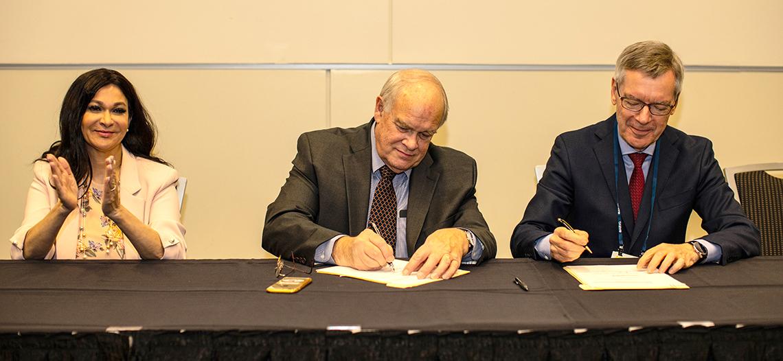 Sieving signs agreement with Gupta and Wiedemann at a table