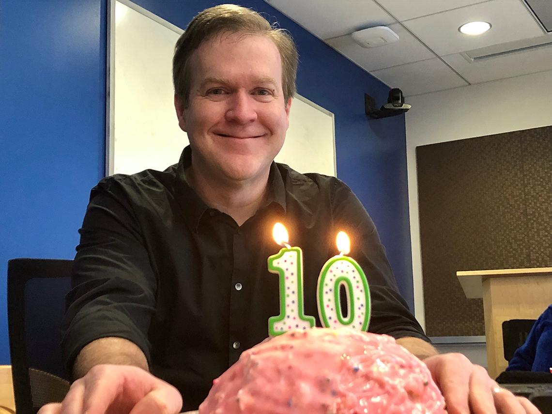 McGavern smiles behind brain-shaped cake with "1" and "0" candles