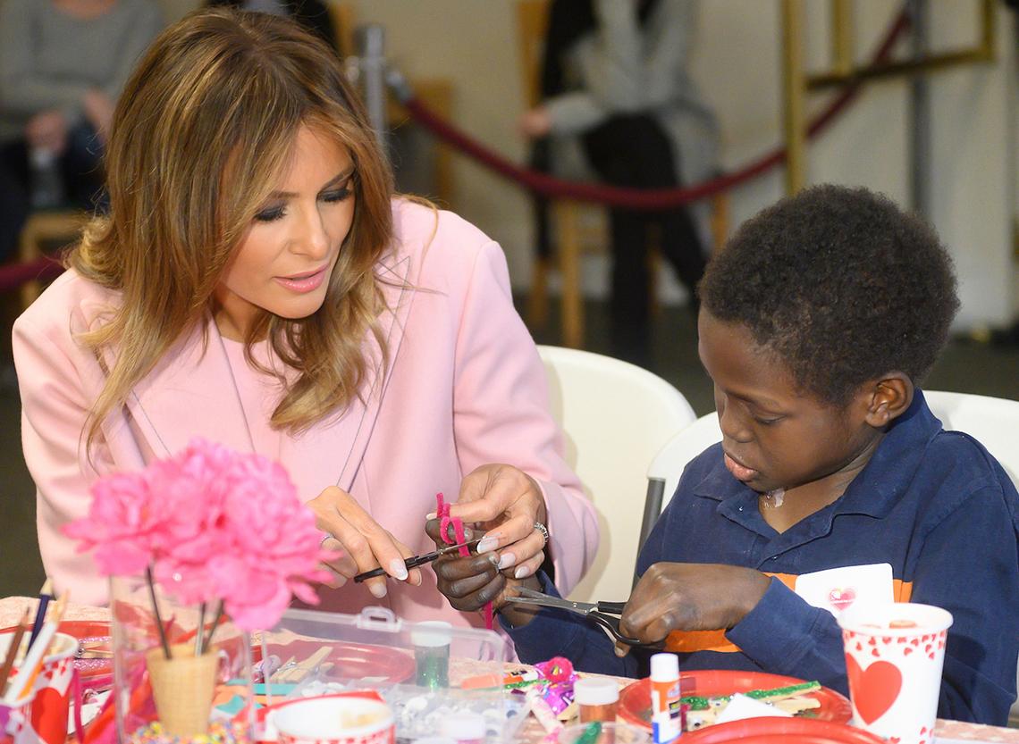 First Lady Trump helps young inn resident use craft scissors and ribbon