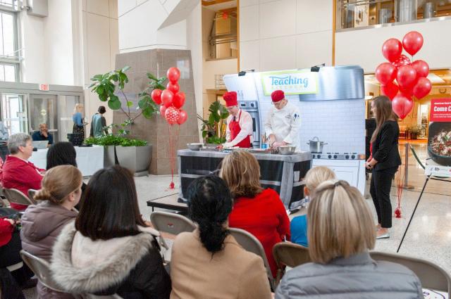 Goff and Fiametta slicing fruit and mixing ingredients in a cooking demonstration