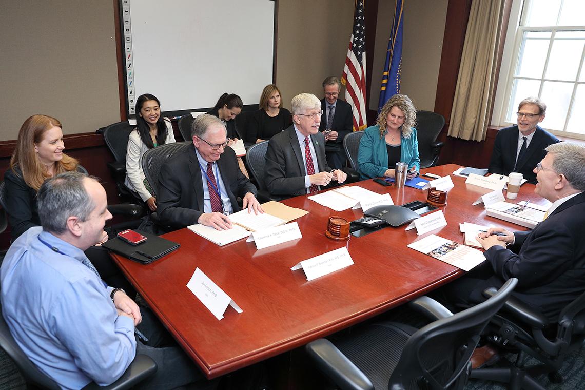 Group seated around mahogany conference table
