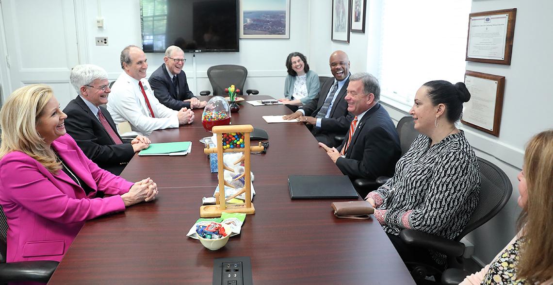 Group seated around mahogany conference table