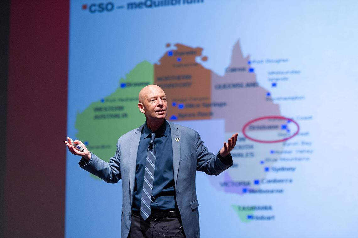 Shatté gestures with slide projected behind him