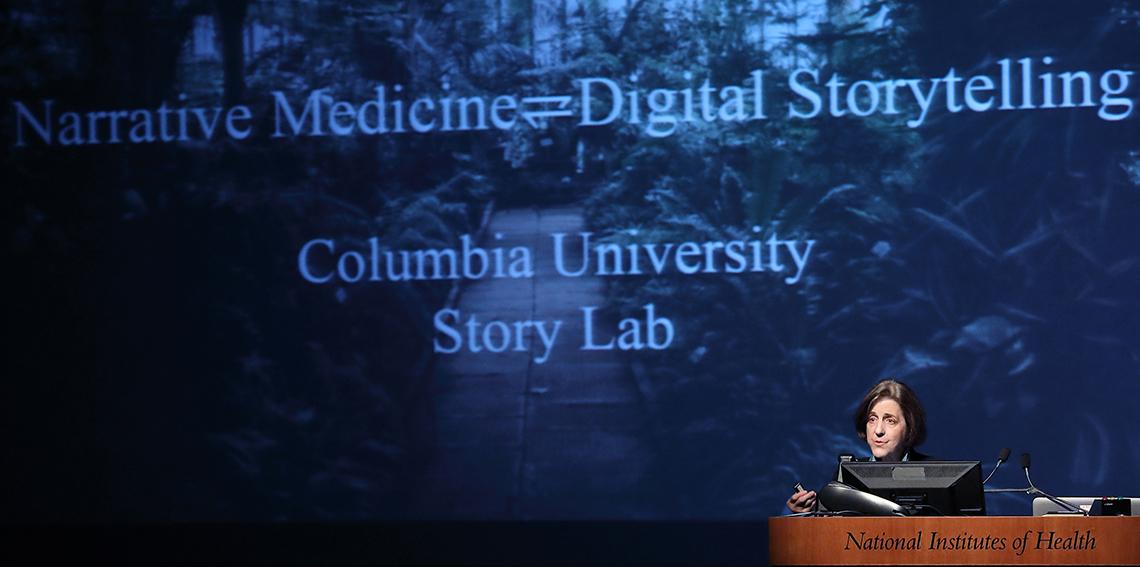 Charon speaks at podium in front of slide that reads narrative medicine equals digital storytelling, Columbia U Story Lab