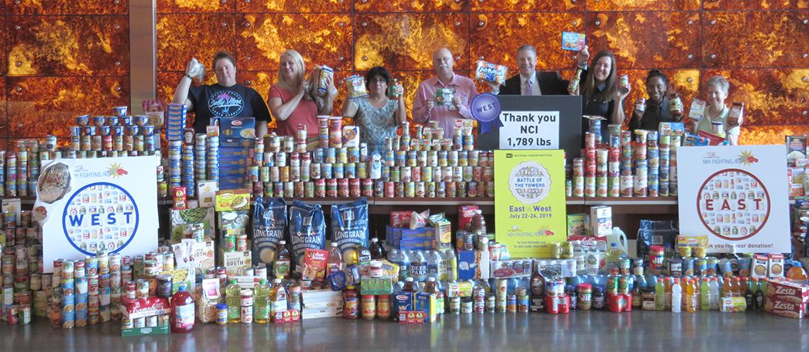 Volunteers display a huge wall of canned foods.