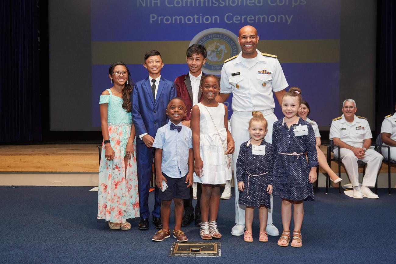 Children pose on stage with Surgeon General Jerome Adams