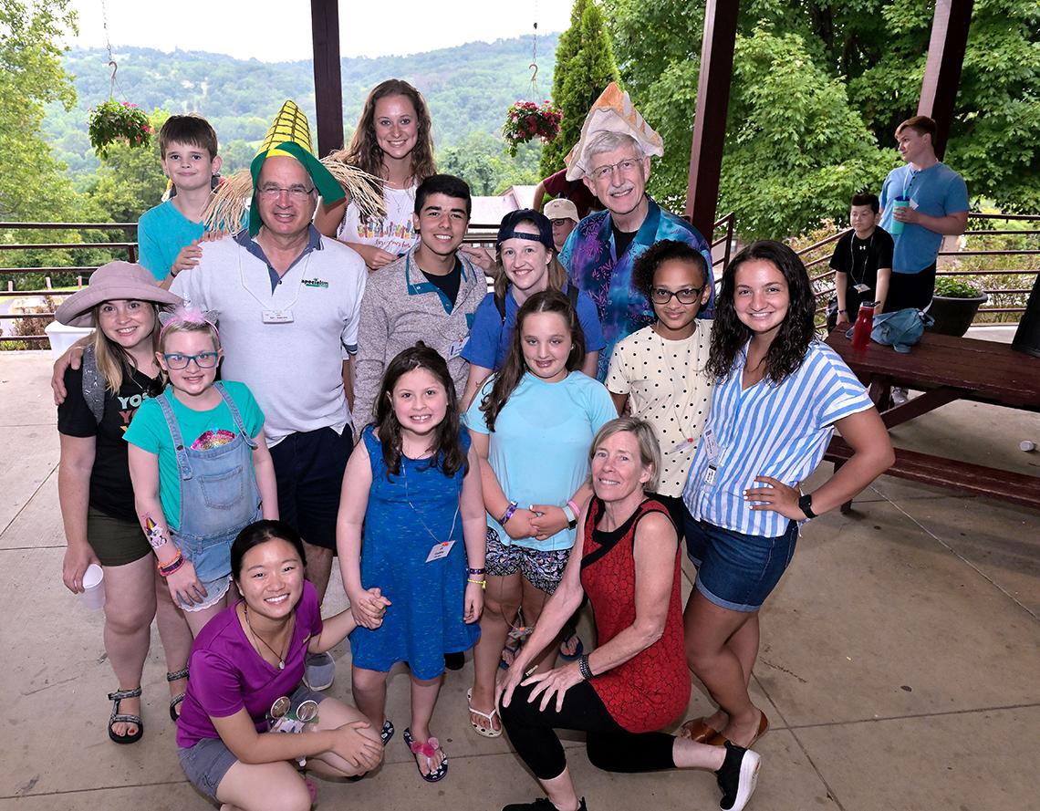 Group of children pose outside with Dr. Collins and his wife at Camp Fantastic.