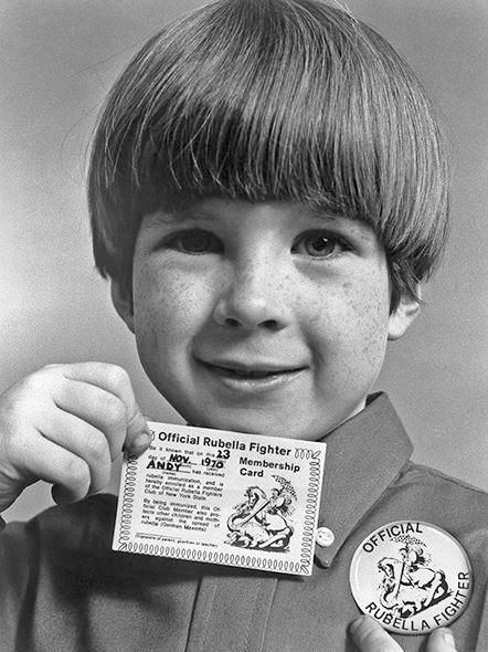 Child proudly displays his “official rubella fighter” card and button.