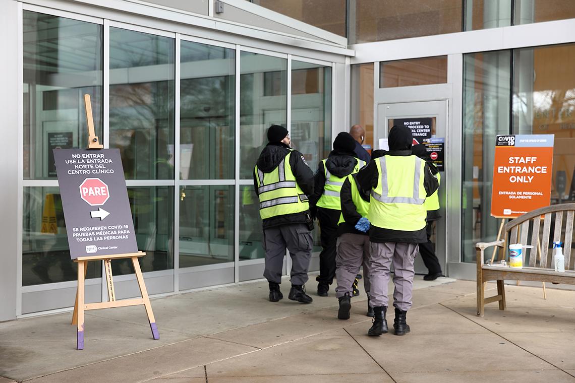 Employees in yellow vests walk through designated staff-only entrance.