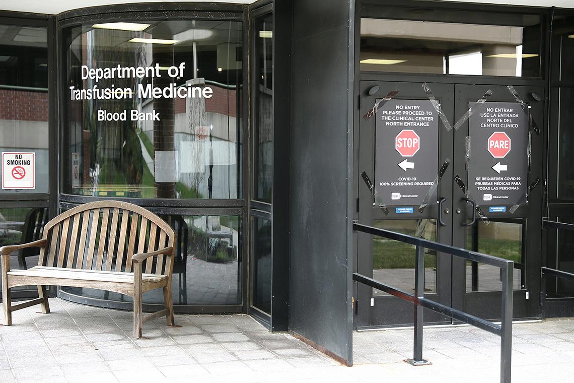 Doors with signs pointing alternative entrances at the Blood Bank.