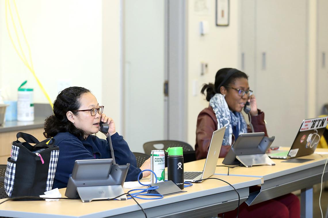 Two people on phones at tables.
