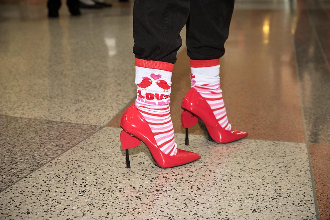 Close-up of red high-heeled shoes with heart shapes on the heels