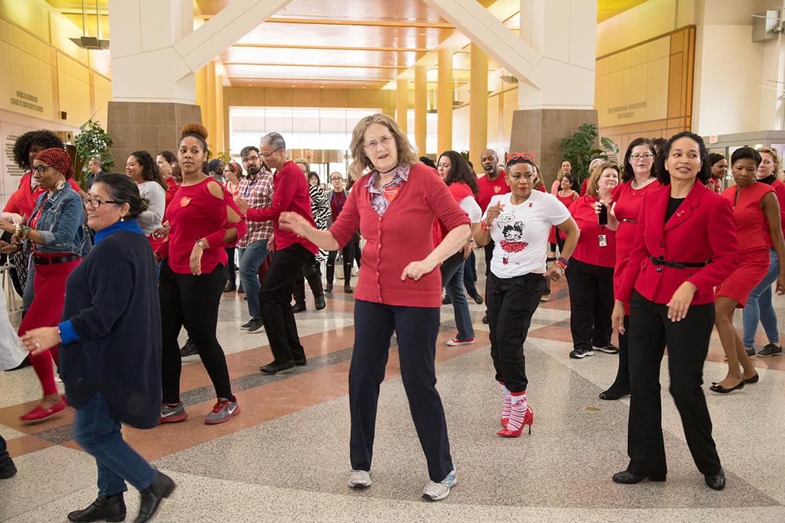 Large group of people dressed in red, dancing.