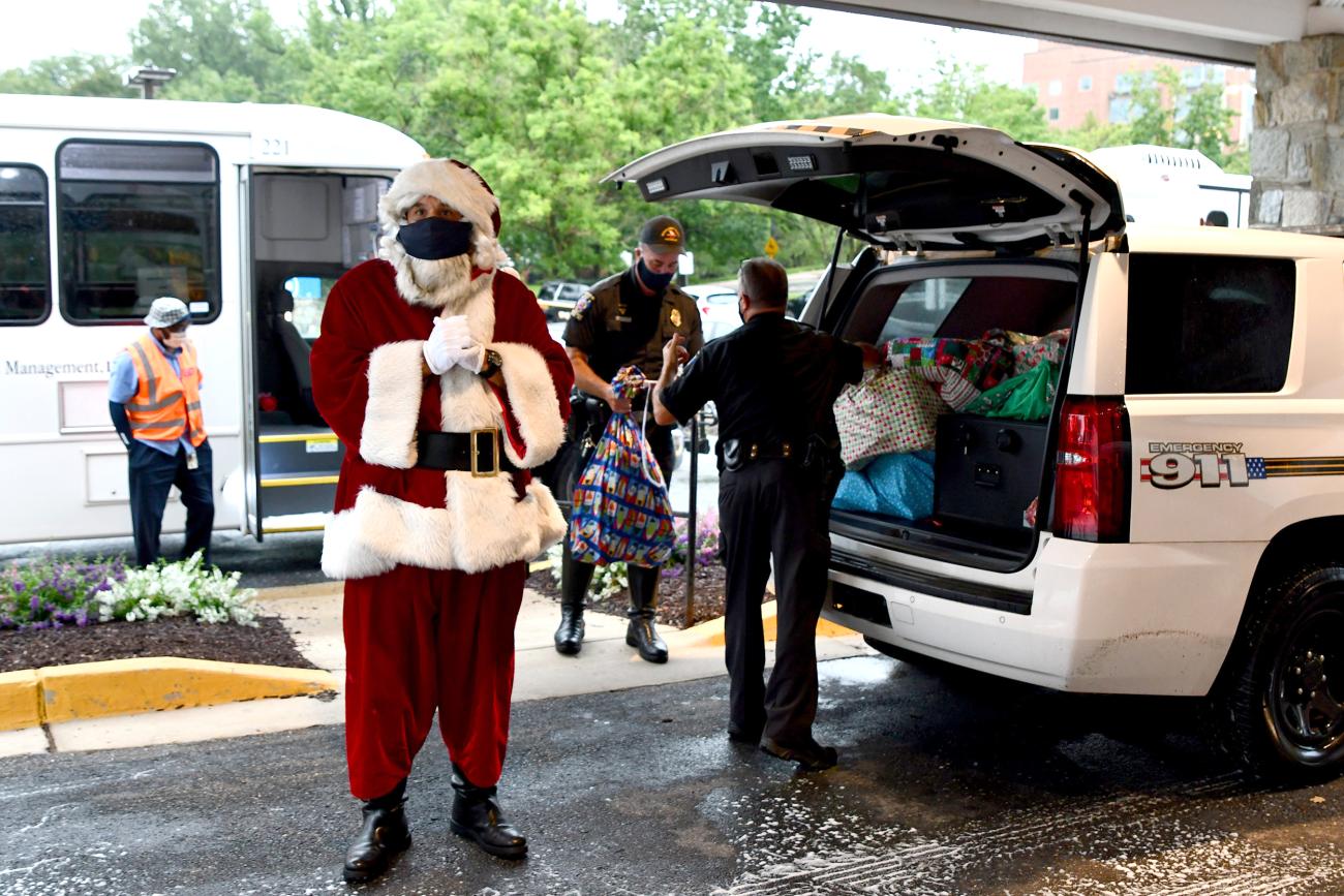 A police officer dressed as Santa arrives at the Children's Inn with bags full of presents for the kids.