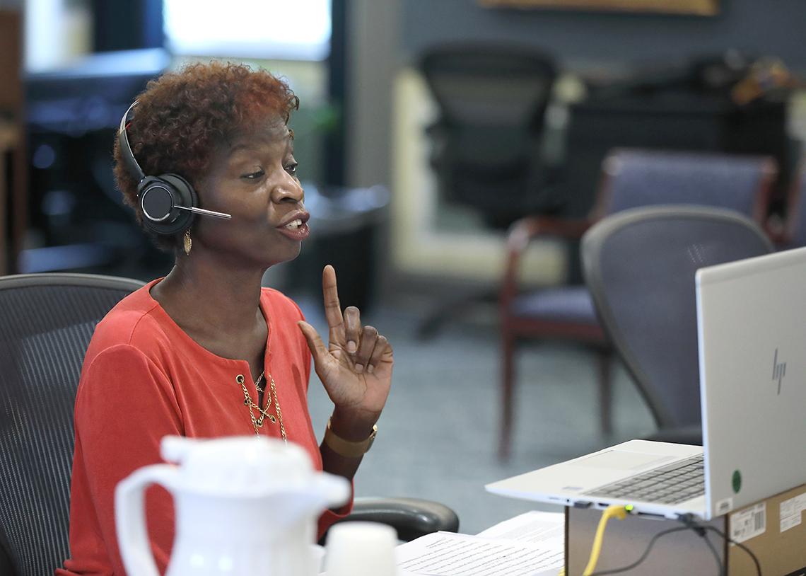 African-American woman in headset seated in front of computer screen