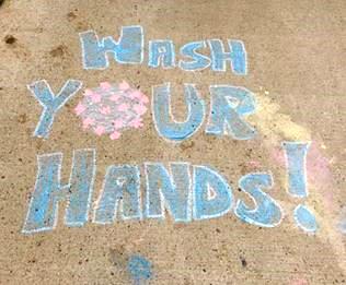 The phrase, "wash your hands!" written in chalk