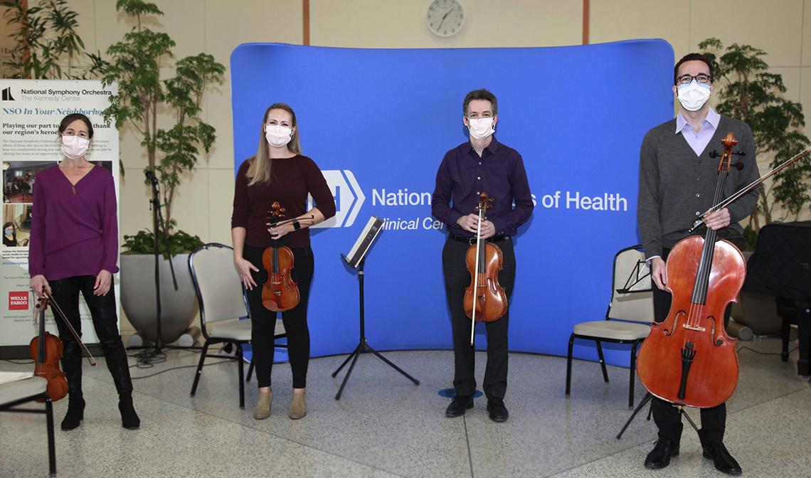 Performers stand with their instruments
