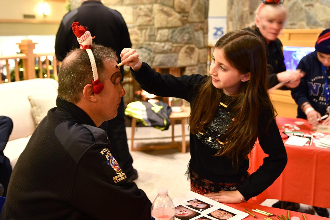 Child paints officer's face.