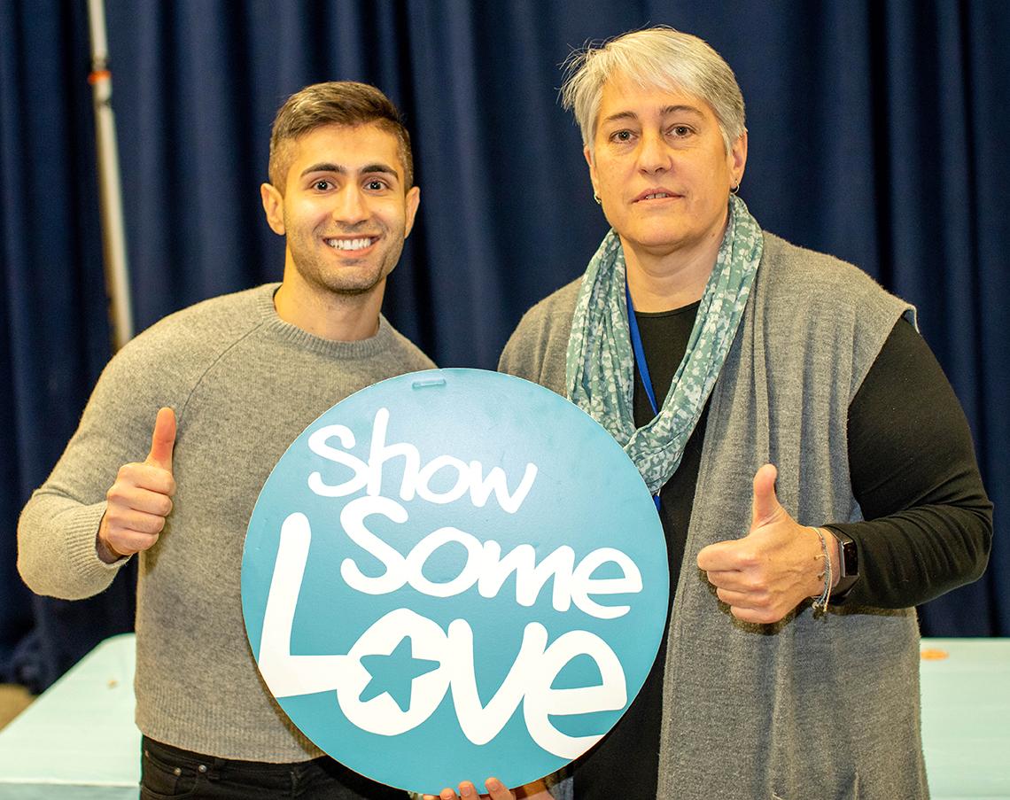 Miranda Jarnot gives thumbs up as she and Pahlavan hold Show Some Love sign