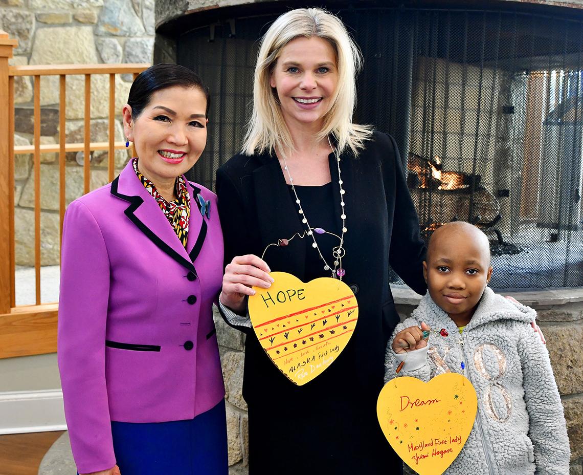 Mrs. Hogan, Jennie Lucca and child, displaying artwork