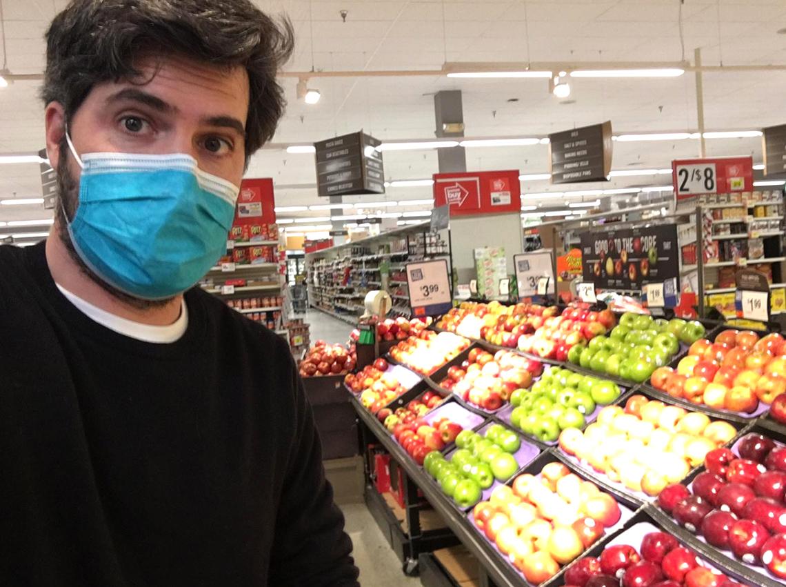 Wearing a mask, Vidal-Ribas stands in the produce section of a grocery store.