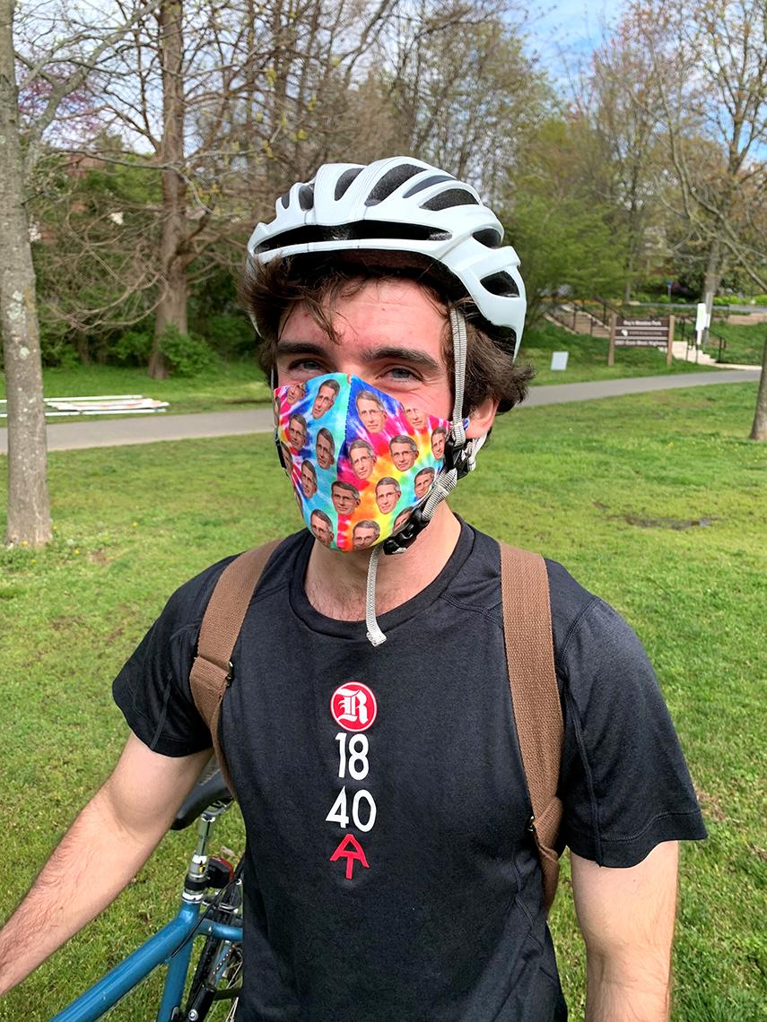 A man in a bike helmet wears a face mask
