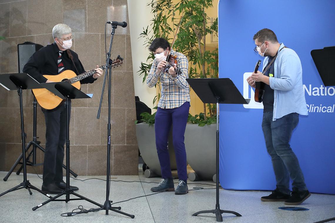 Three musicians play bluegrass music.