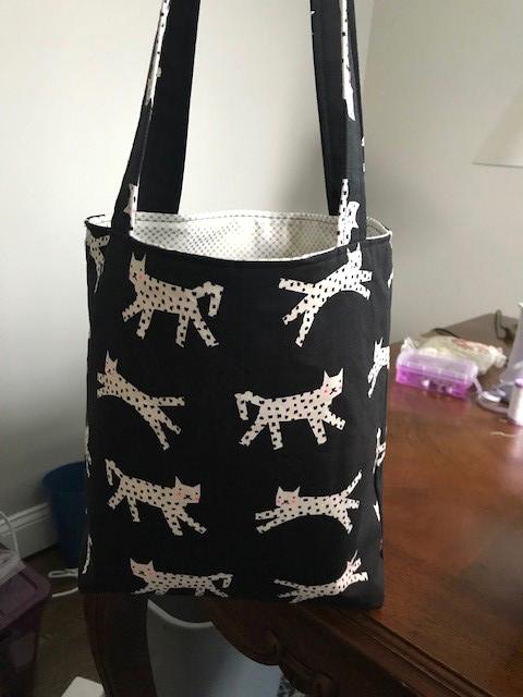 A black bag featuring cartoon cats