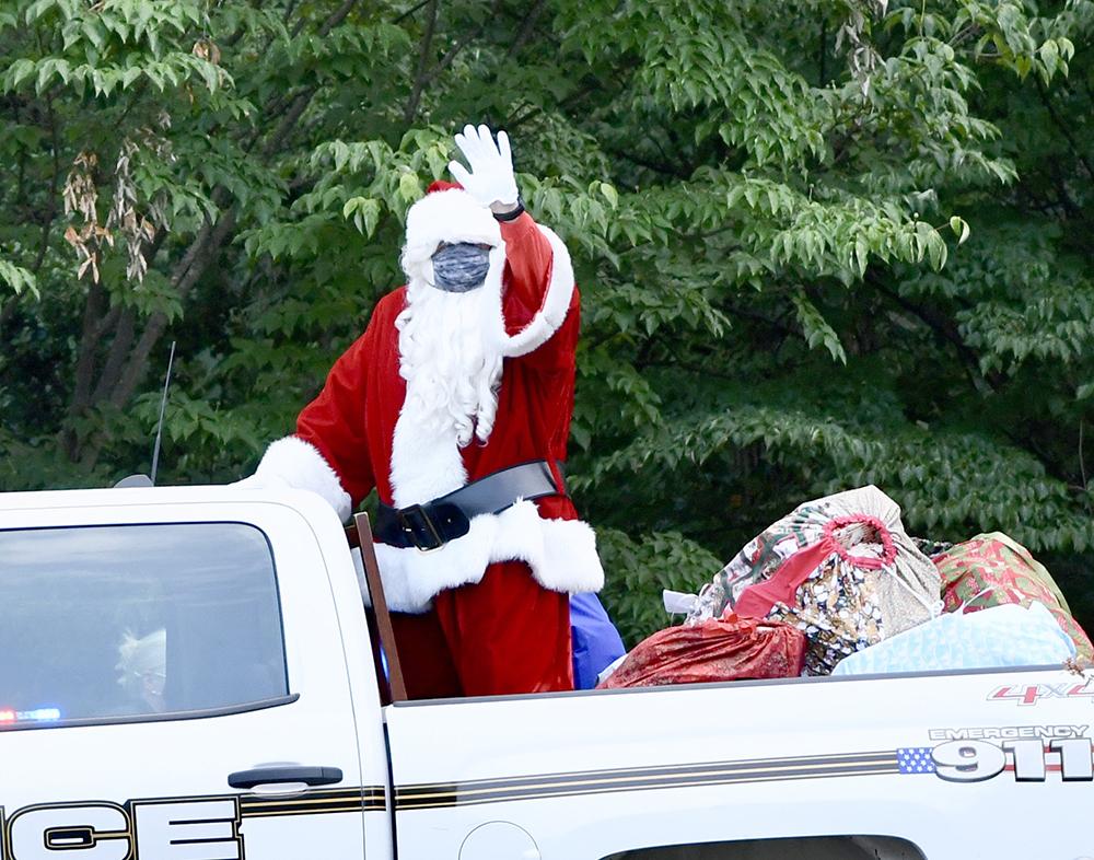 Santa waves from the bed of a pickup truck