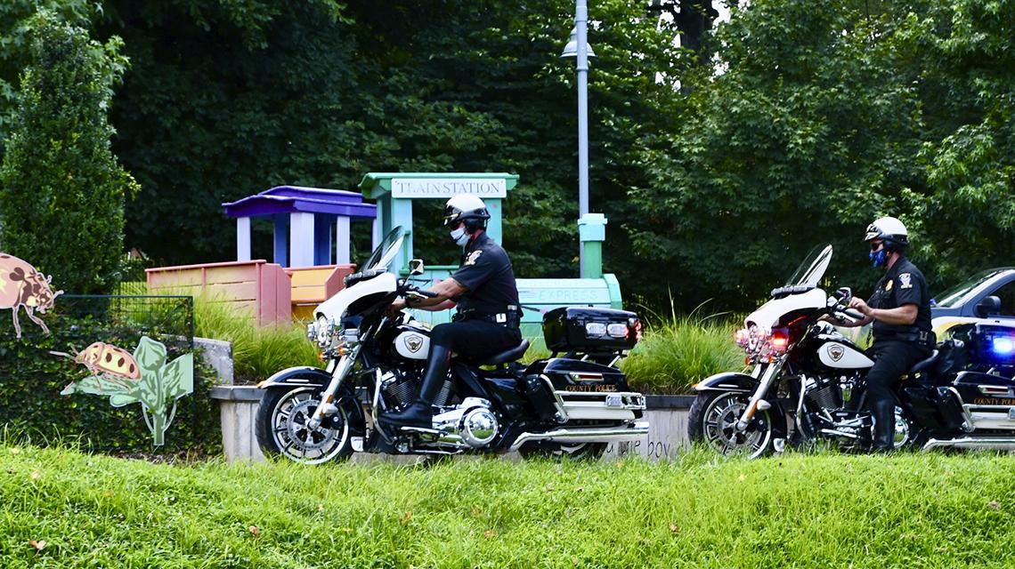 Two police officers riding motorcycles drive up to the inn. 