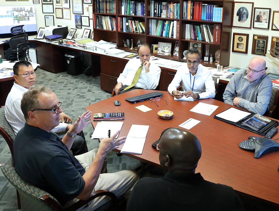 McManus sits at a conference table with several others