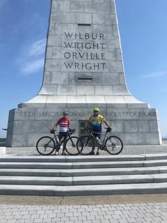 Steve Friedman and friend stand with their bicycles on steps of Wright Brothers Memorial.