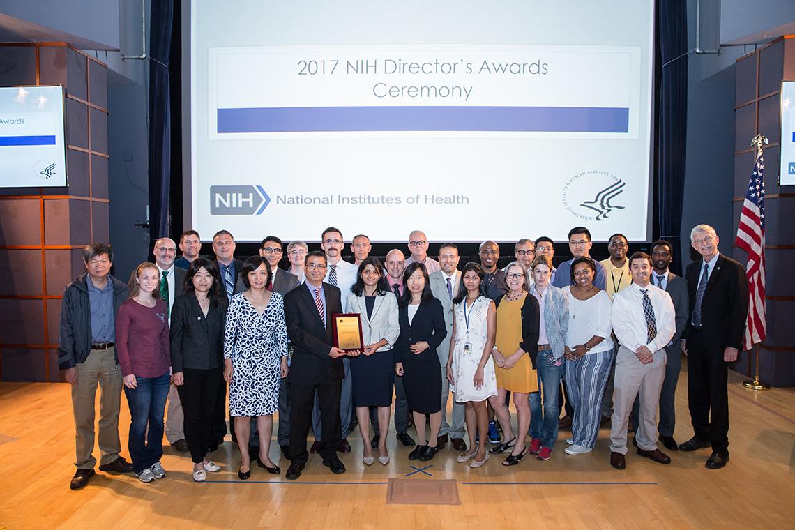Bharti's team gets their photo taken on the stage with Collins after they received the award