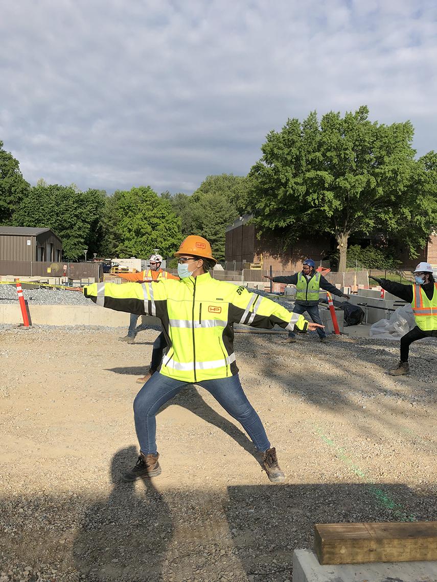 Close up view of individual construction worker with knees bended and arms stretched out