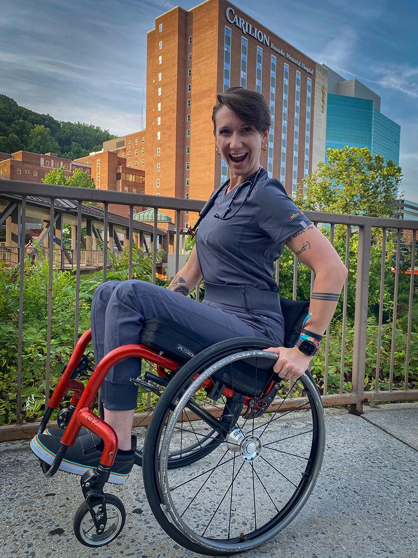 Mason performs a "wheelie" in her wheelchair on a walkway in front of her hospital
