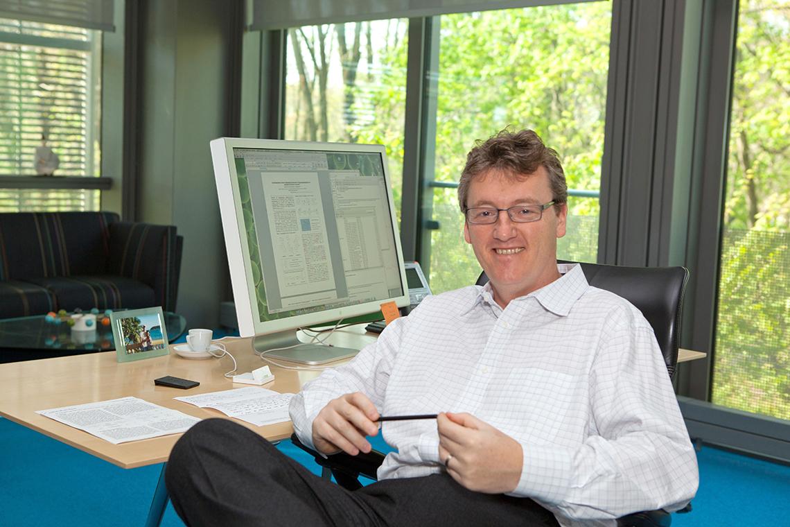 MacMillan sits at his desk