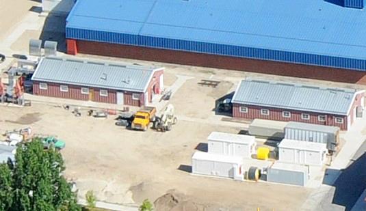 birdseye view of two identical 1-story structures side by side, with several smaller storage units in foreground