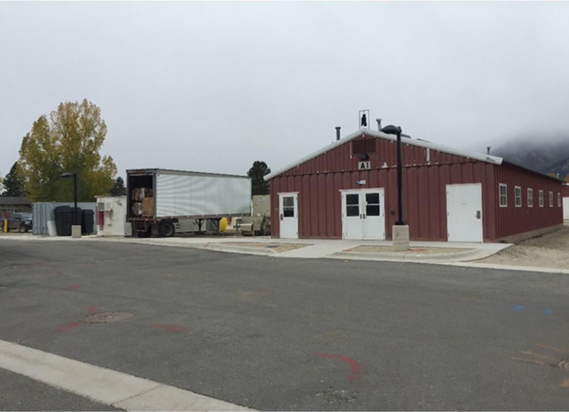 ground-level view of one-story barn-like structure with asphalt lane in front