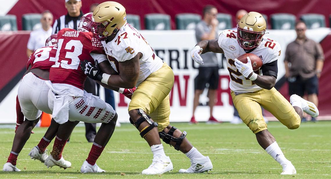 College football game play. Johnson blocks for running back.