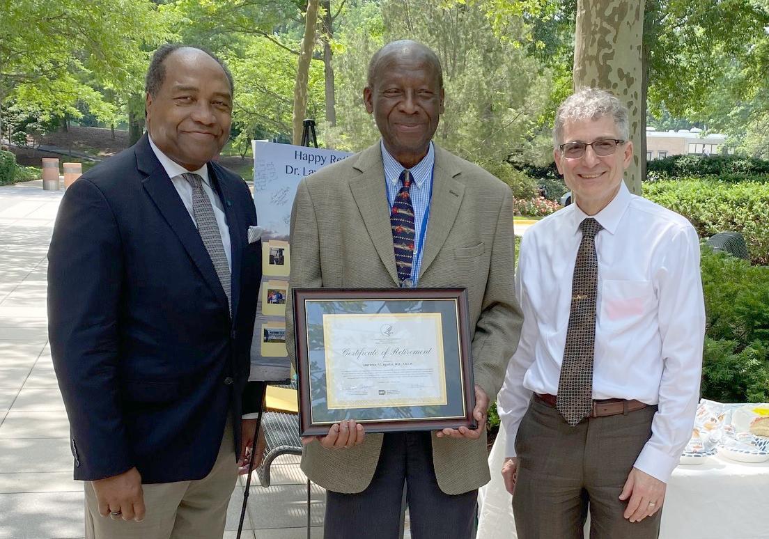 Agodoa holds a plaque. He stands in-between Rodgers and Germino 