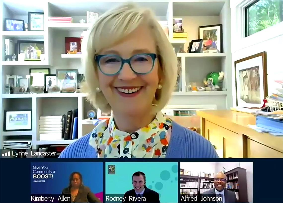 A screenshot shows a smiling Lancaster talking with Allen, Rivera and Johnson, all smiling.