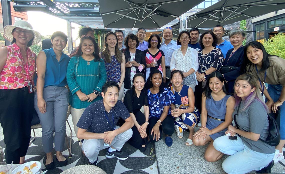 Large group of people smile under pavilion covers