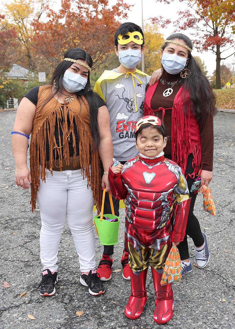 Four individuals of various heights, in costumes, pose for photo