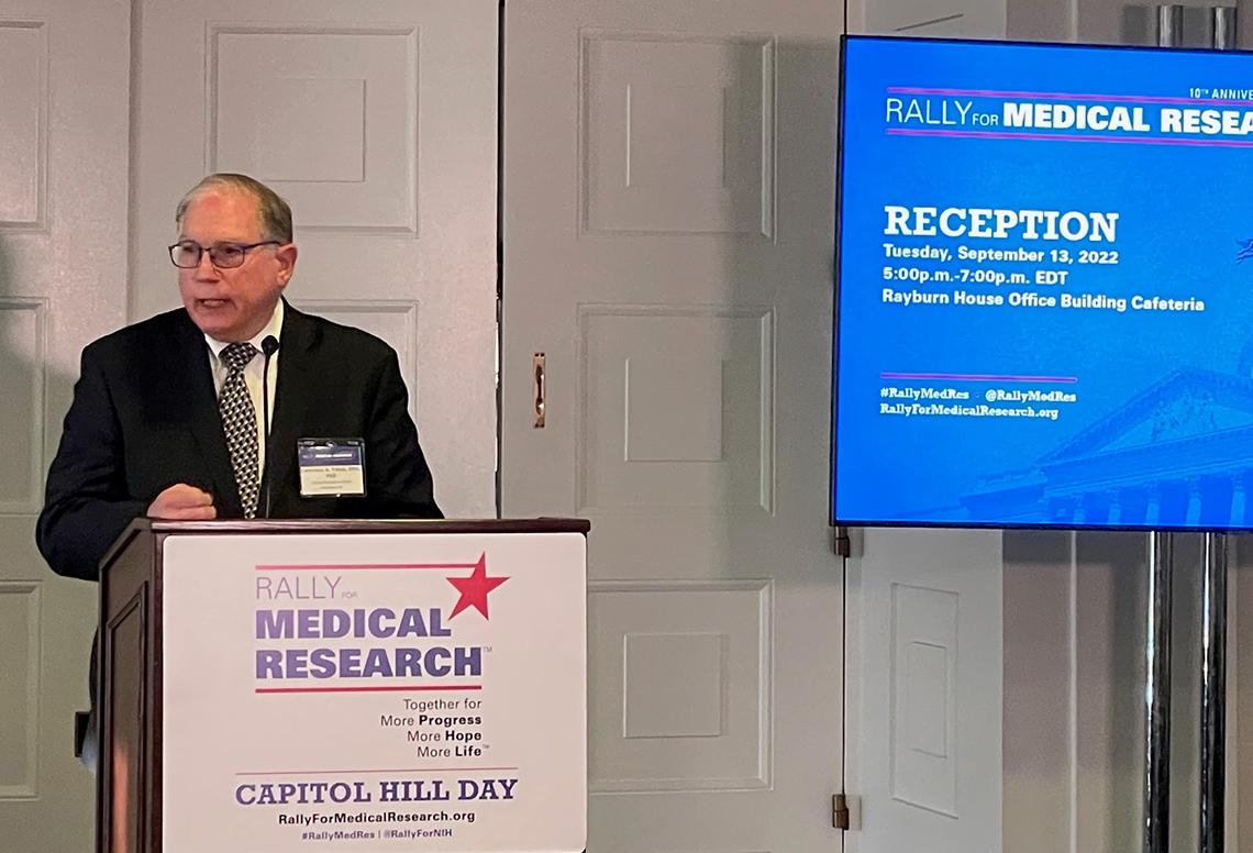 Tabak speaks at a podium