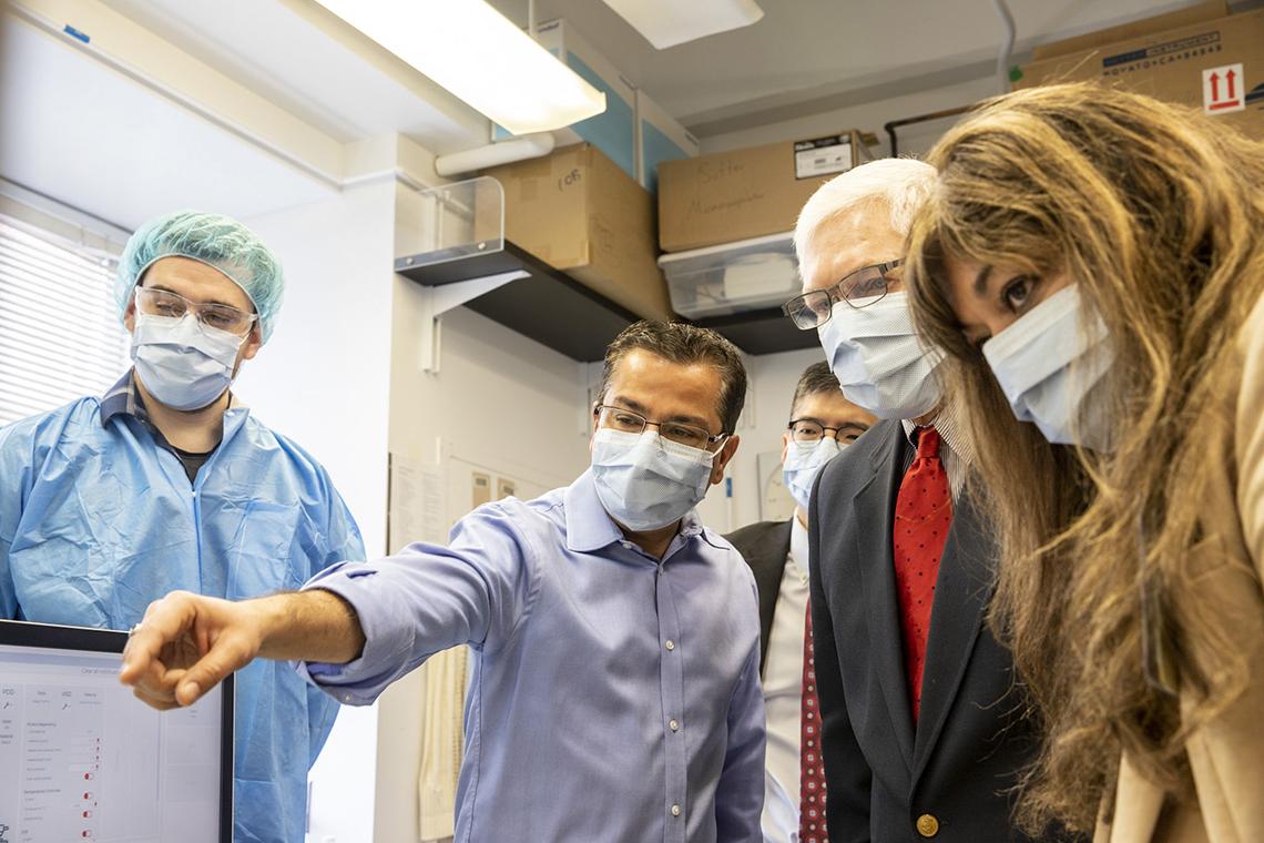 Sessions and a a group look at where Bharti points off screen