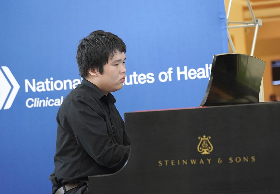 Man looks at music while playing piano.